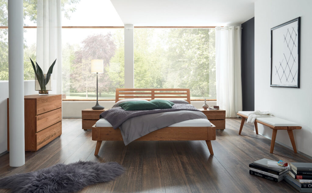 Ein lichtdurchflutetes Schlafzimmer mit einem gemütlichen Bett und stilvollen Deko-Elementen.